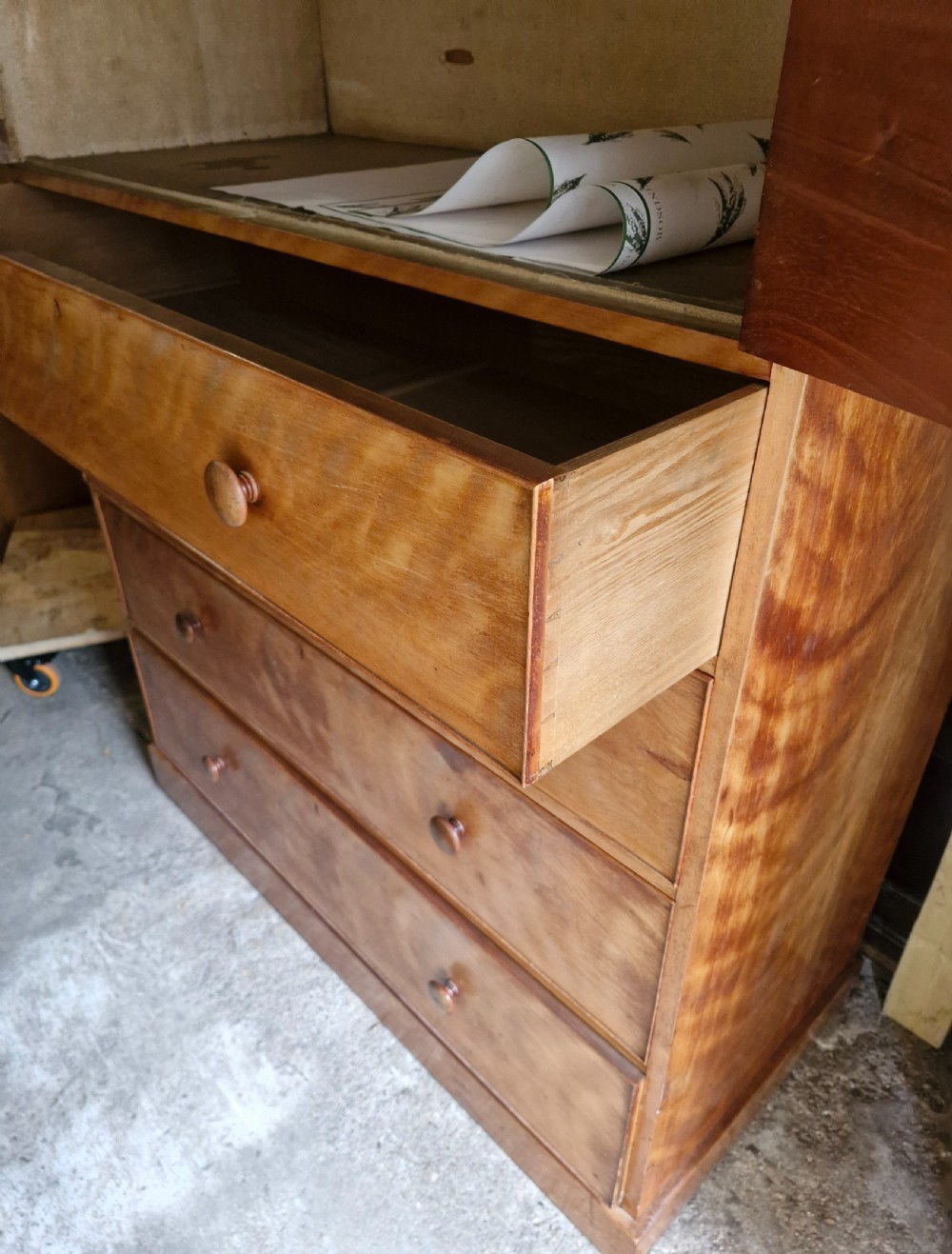 An oversized Victorian satinbirch chest of drawers featuring flame-figured wood grain, turned wooden knobs, and a solid plinth base. View V