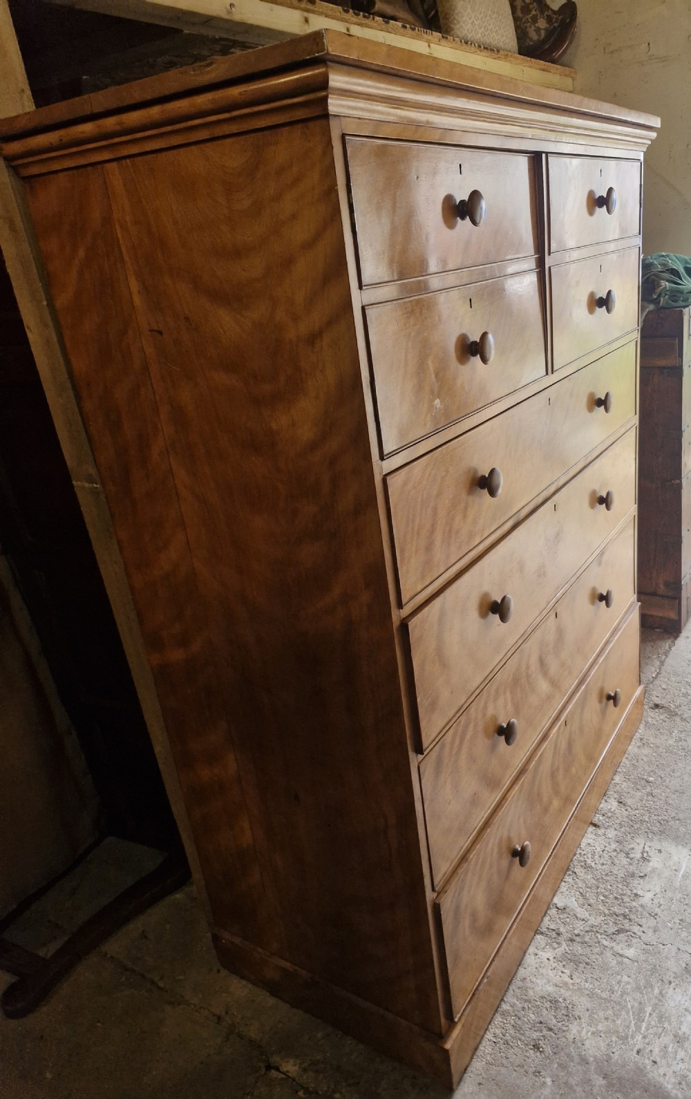 An oversized Victorian satinbirch chest of drawers featuring flame-figured wood grain, turned wooden knobs, and a solid plinth base. View VIII