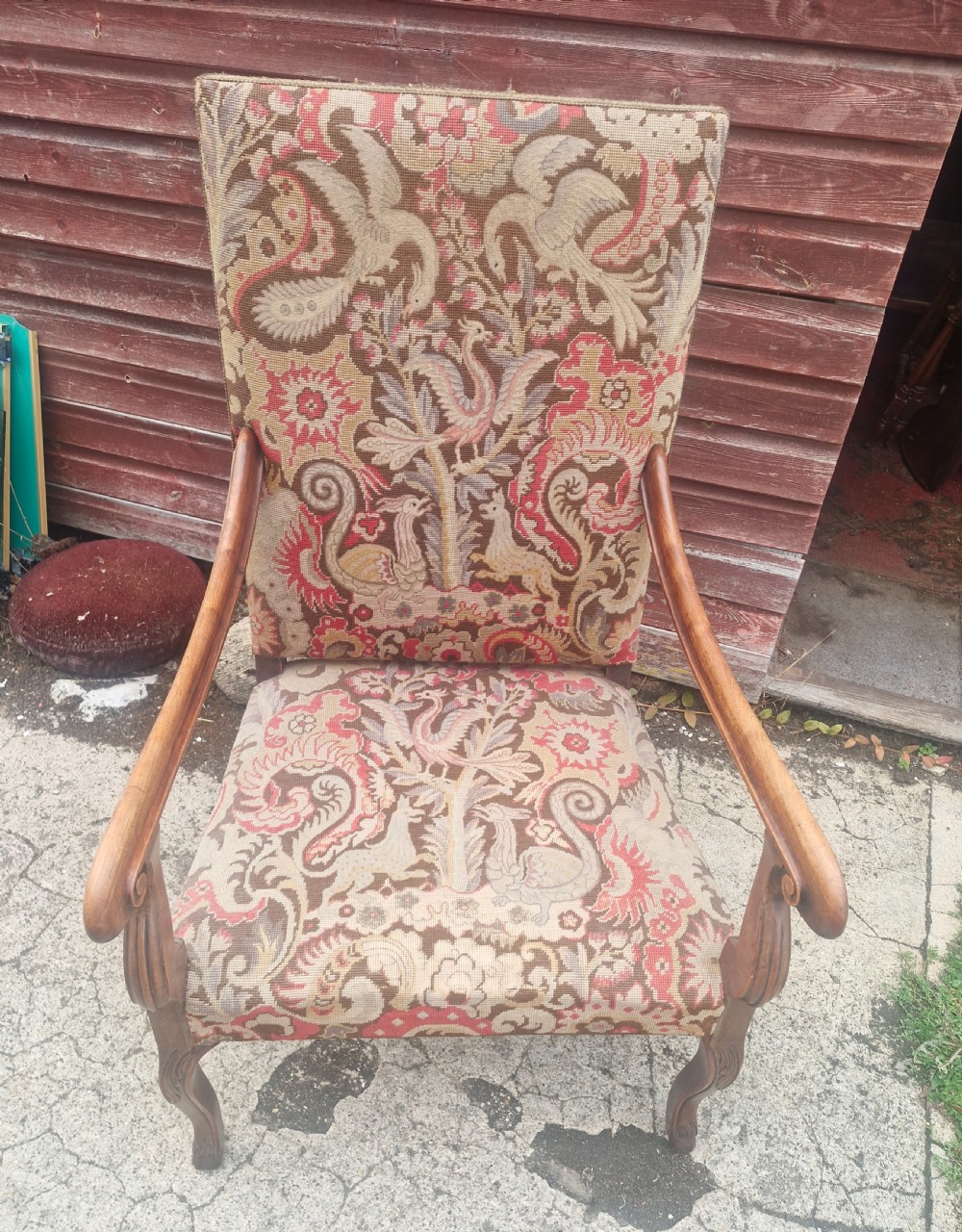 A high-backed open armchair upholstered in patterned tapestry depicting mythical bird motifs, supported by carved wooden cabriole legs. View III