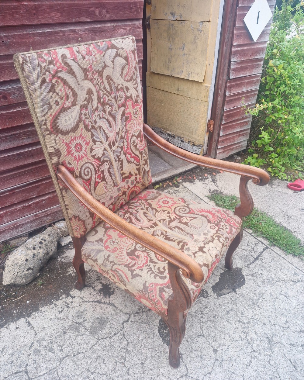 A high-backed open armchair upholstered in patterned tapestry depicting mythical bird motifs, supported by carved wooden cabriole legs. View IV