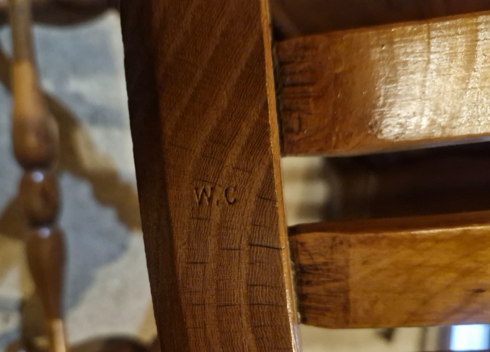 A Victorian wooden Windsor armchair featuring a shaped crest rail, vertical spindles, a contoured saddle seat, curved armrests, and turned legs. View VII