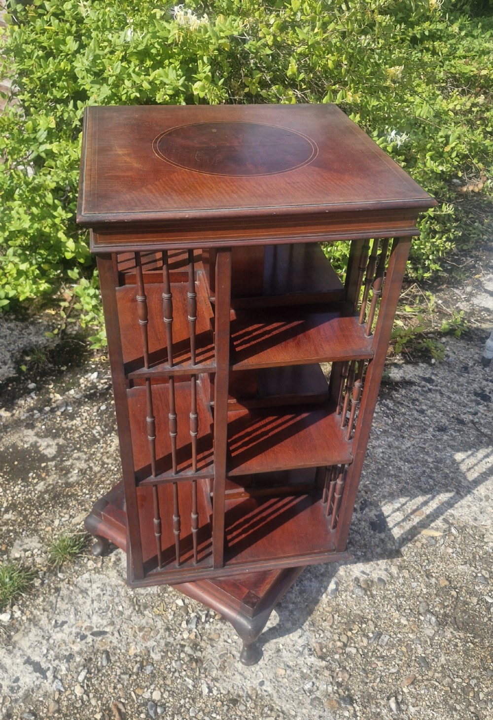 Edwardian inlaid mahogany revolving bookcase with makers stamp.