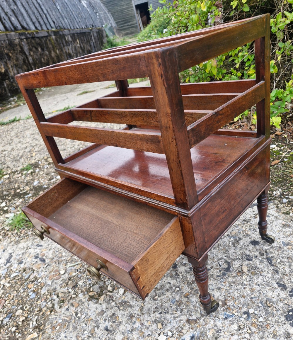 A Regency mahogany music Canterbury featuring slotted upper dividers, a single lower drawer with brass knobs, and turned legs with brass castors. View III