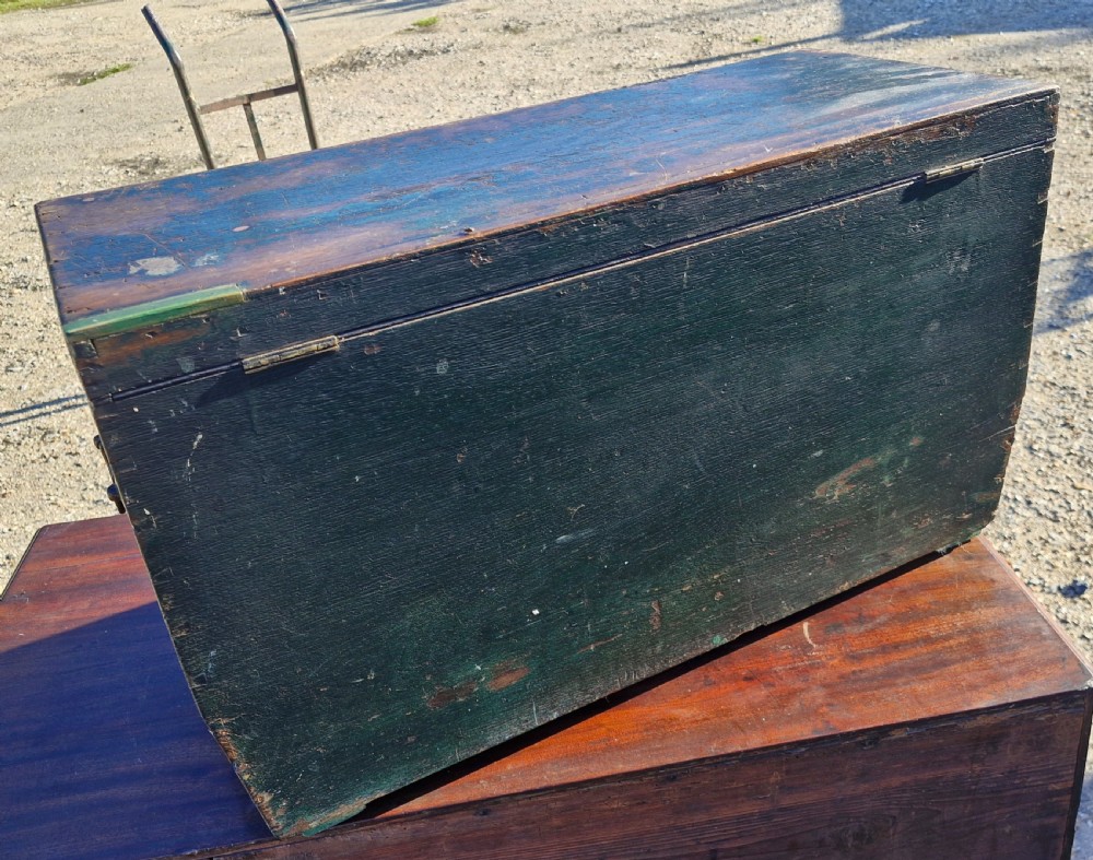 An early 19th-century rectangular oak coaching trunk featuring a distressed dark green painted finish, brass side handles, hand-cut dovetail joints, and an iron keyhole escutcheon. View VI