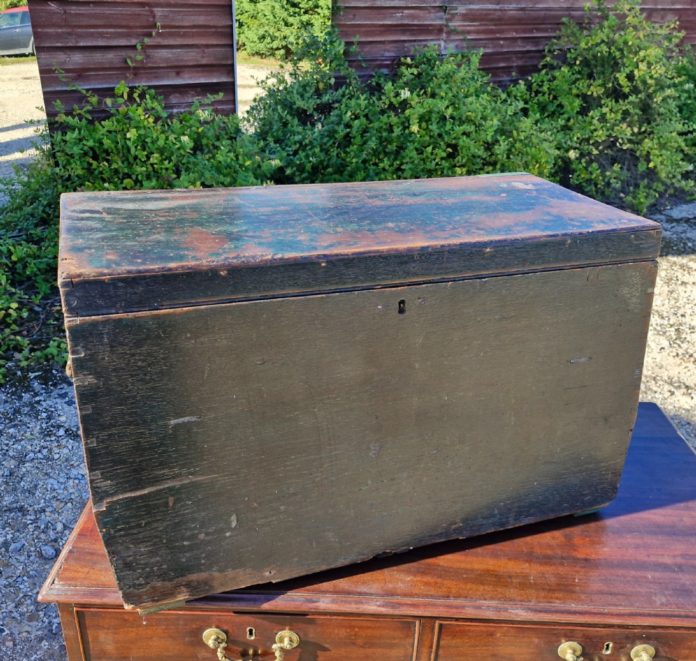 An early 19th-century rectangular oak coaching trunk featuring a distressed dark green painted finish, brass side handles, hand-cut dovetail joints, and an iron keyhole escutcheon. View VII