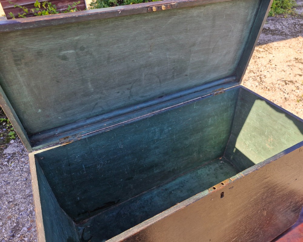 An early 19th-century rectangular oak coaching trunk featuring a distressed dark green painted finish, brass side handles, hand-cut dovetail joints, and an iron keyhole escutcheon. View VIII
