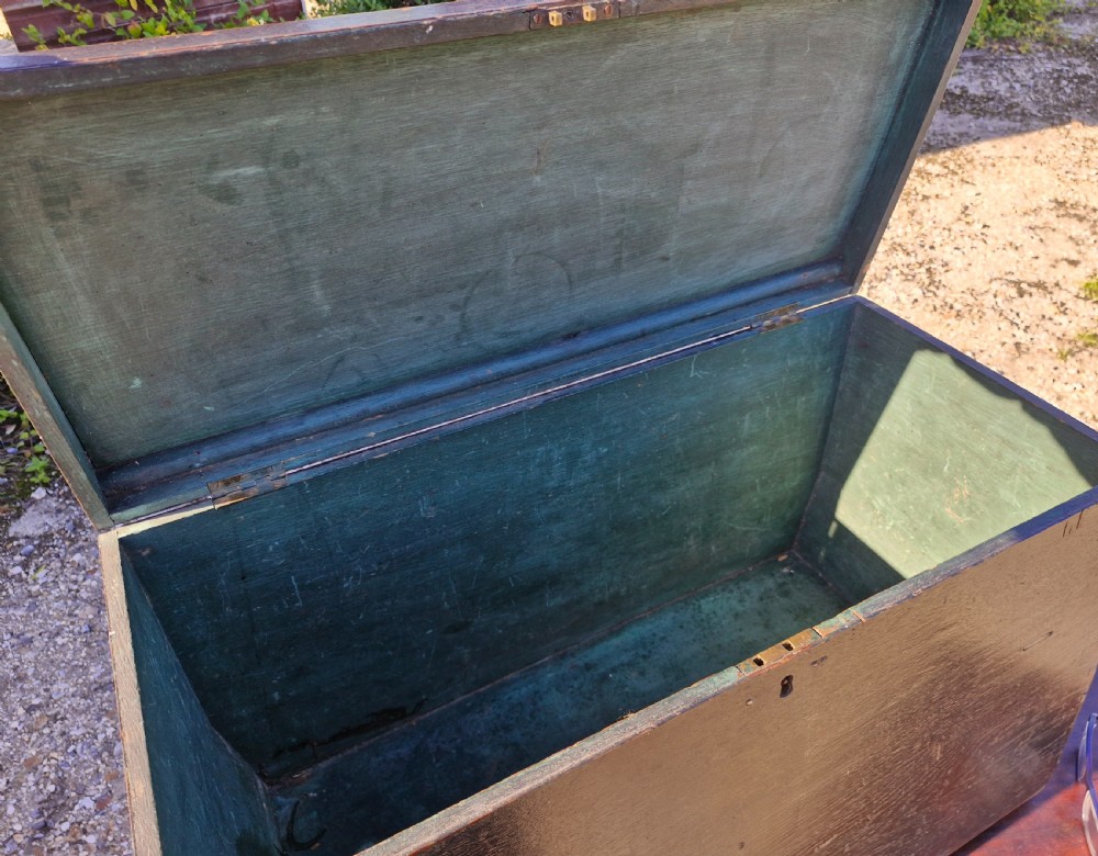 An early 19th-century rectangular oak coaching trunk featuring a distressed dark green painted finish, brass side handles, hand-cut dovetail joints, and an iron keyhole escutcheon. View IX