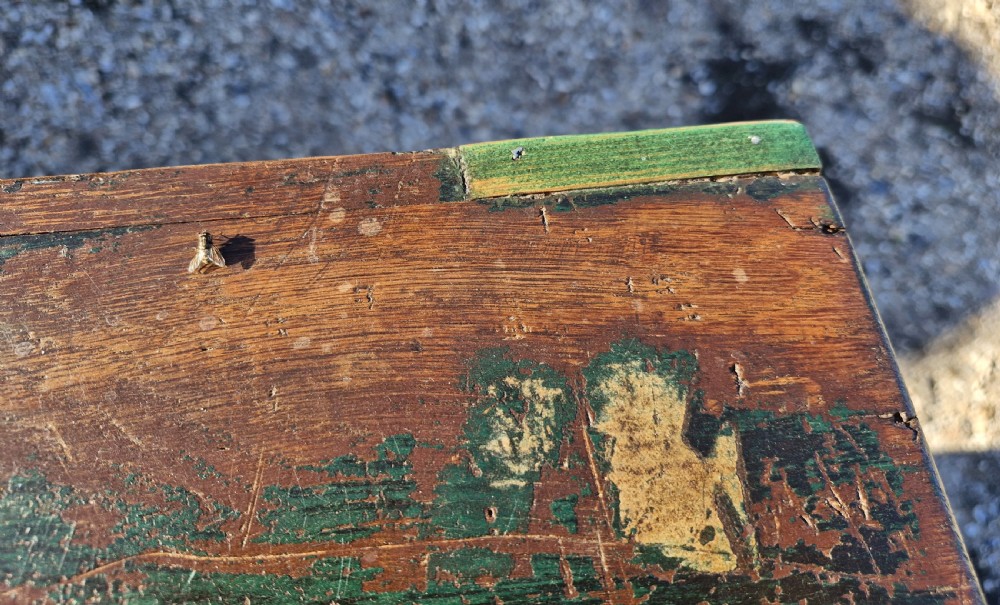 An early 19th-century rectangular oak coaching trunk featuring a distressed dark green painted finish, brass side handles, hand-cut dovetail joints, and an iron keyhole escutcheon. View XI