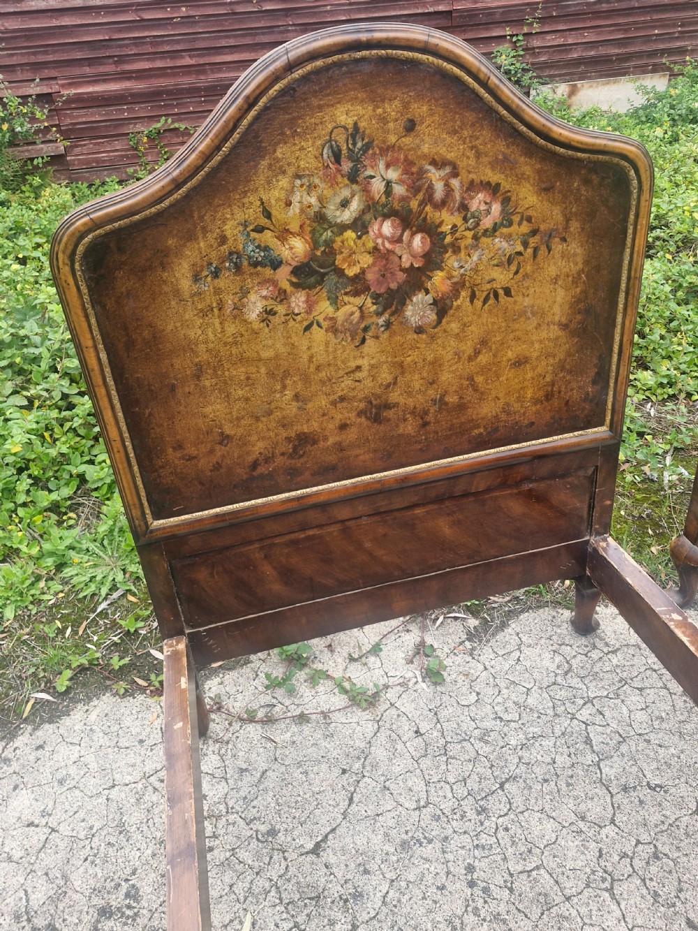 A pair of antique walnut single bed frames featuring arched headboards with floral painted leather panels and scrolled footboard posts. View III