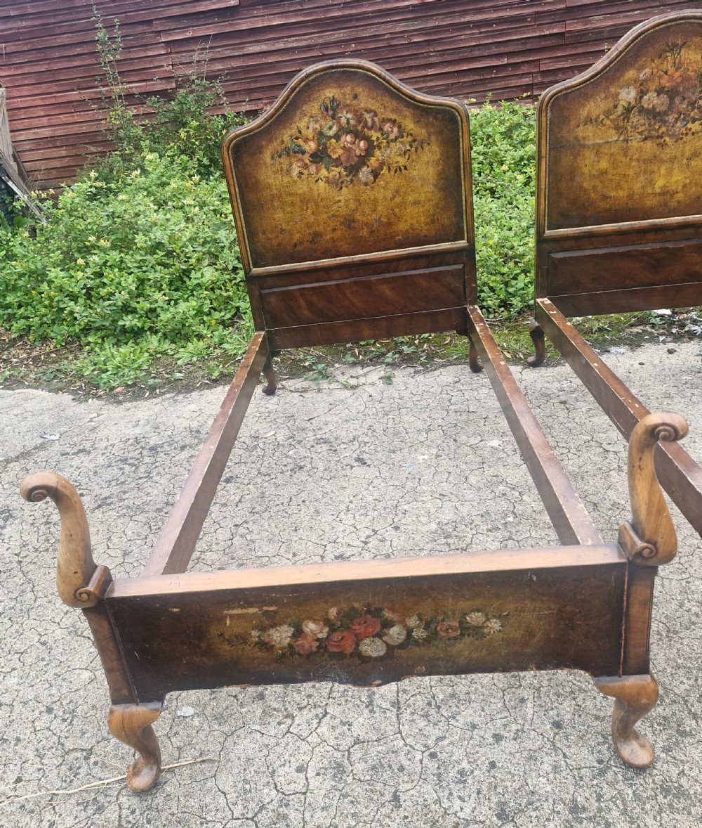 A pair of antique walnut single bed frames featuring arched headboards with floral painted leather panels and scrolled footboard posts. View VI
