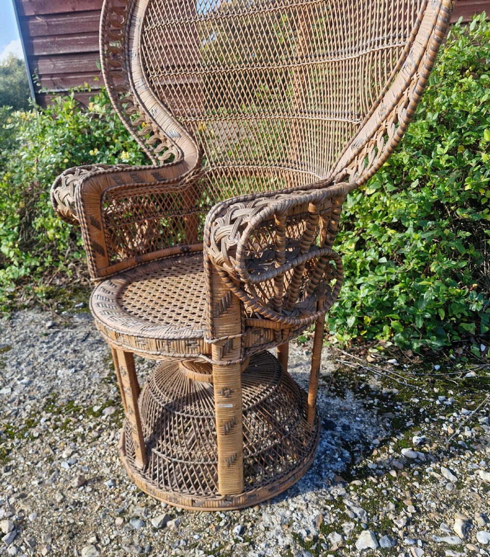 A high-backed woven cane peacock armchair featuring a flared fan backrest with lattice weaving, integrated armrests, and an hourglass pedestal base. View II