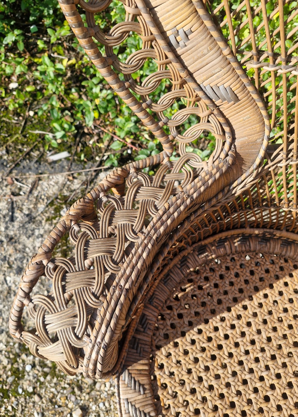 A high-backed woven cane peacock armchair featuring a flared fan backrest with lattice weaving, integrated armrests, and an hourglass pedestal base. View V