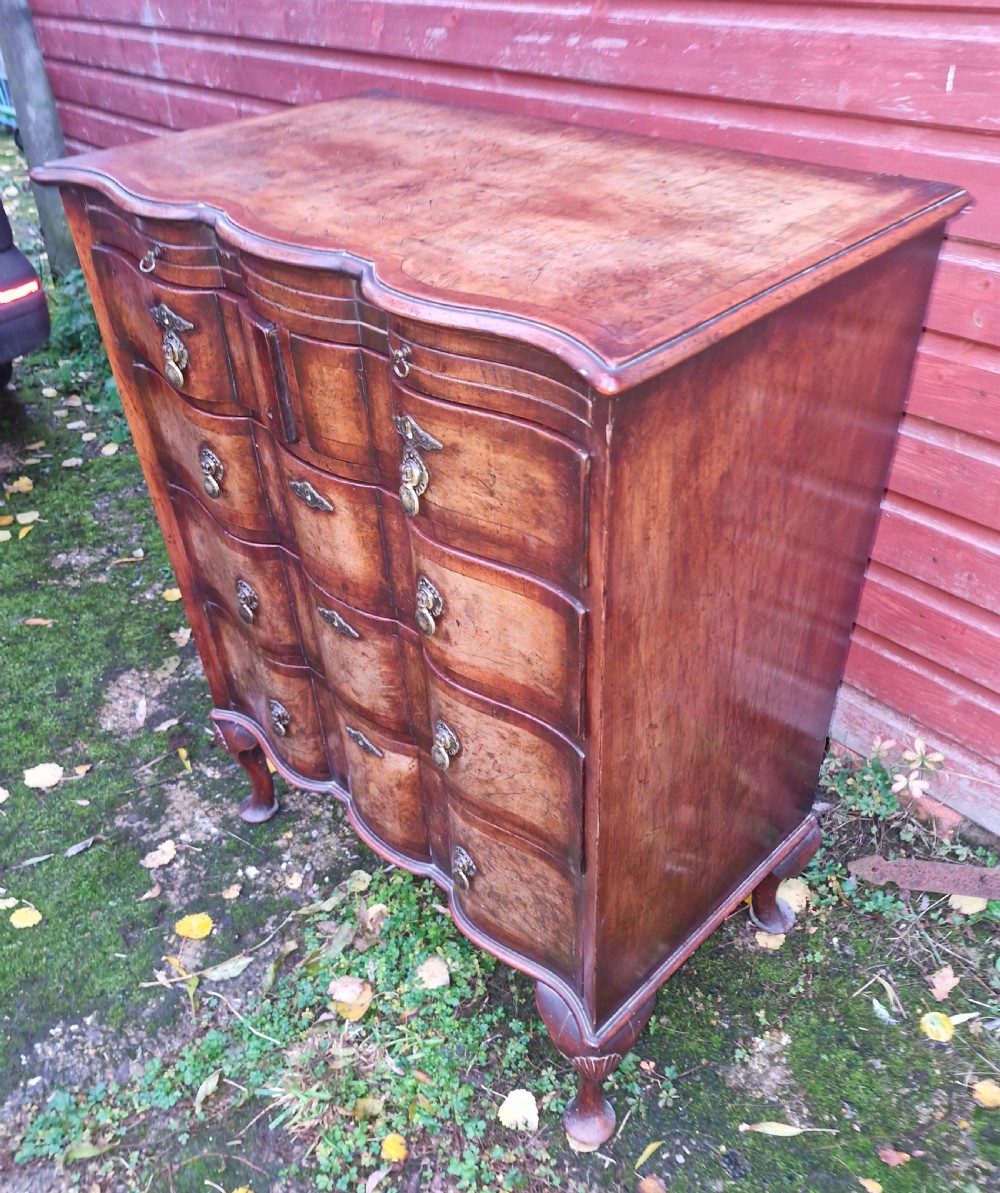 Early 20th century walnut serpentine front chest with brushing slide. 