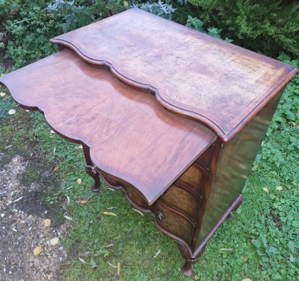 Early 20th century walnut serpentine front chest with brushing slide.  View VIII