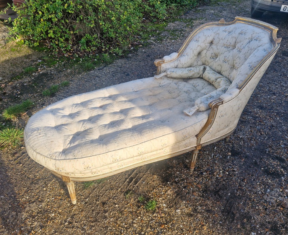 An early 20th-century French style giltwood day bed featuring button-tufted cream floral fabric, fluted tapered legs, and an asymmetrical curved backrest. View II
