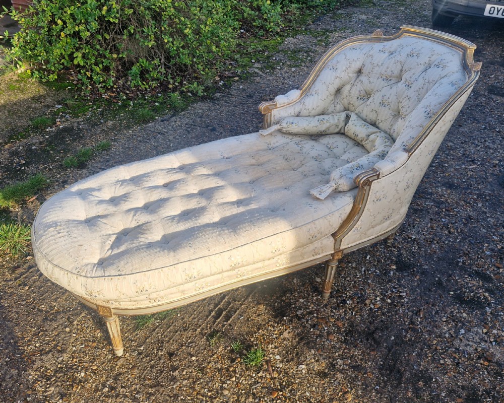 An early 20th-century French style giltwood day bed featuring button-tufted cream floral fabric, fluted tapered legs, and an asymmetrical curved backrest. View III