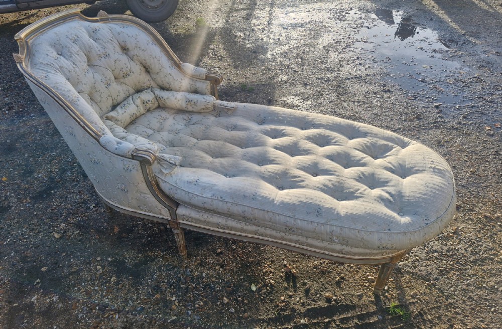 An early 20th-century French style giltwood day bed featuring button-tufted cream floral fabric, fluted tapered legs, and an asymmetrical curved backrest. View VIII