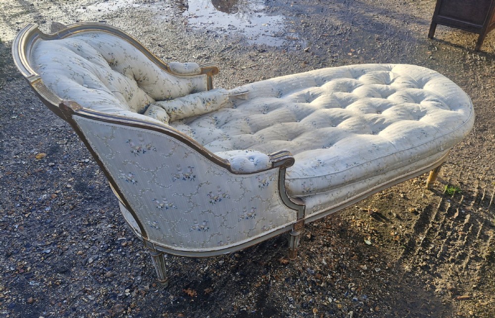 An early 20th-century French style giltwood day bed featuring button-tufted cream floral fabric, fluted tapered legs, and an asymmetrical curved backrest. View XI