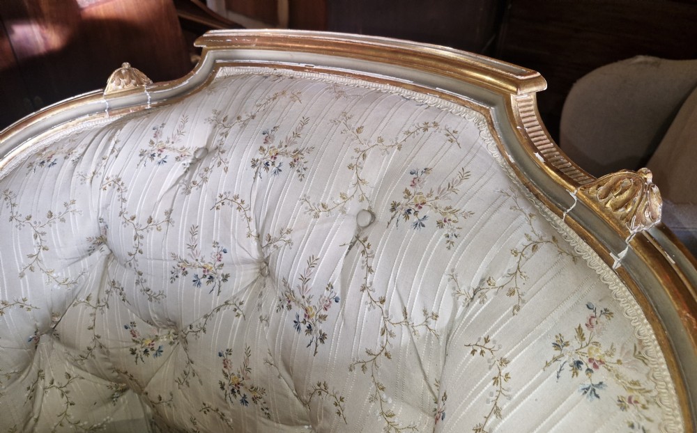 An early 20th-century French style giltwood day bed featuring button-tufted cream floral fabric, fluted tapered legs, and an asymmetrical curved backrest. View XIII
