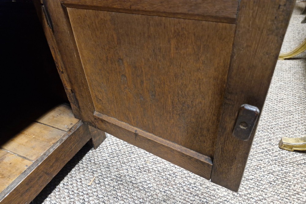 An early nineteenth-century two-part dark oak Welsh dresser featuring a three-shelf plate rack over a sideboard base with drawers and fielded panel cupboard doors. View X