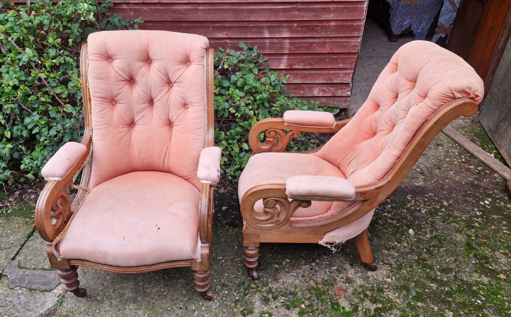 A pair of Victorian mahogany library armchairs featuring button-tufted peach fabric upholstery, scrolled wooden armrests, and turned front legs on casters. View VIII