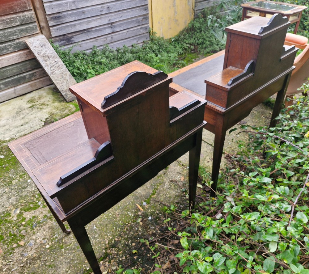 A pair of late Victorian rosewood writing tables featuring central raised cupboards with urn inlay, leather surfaces, and tapered square legs. View II