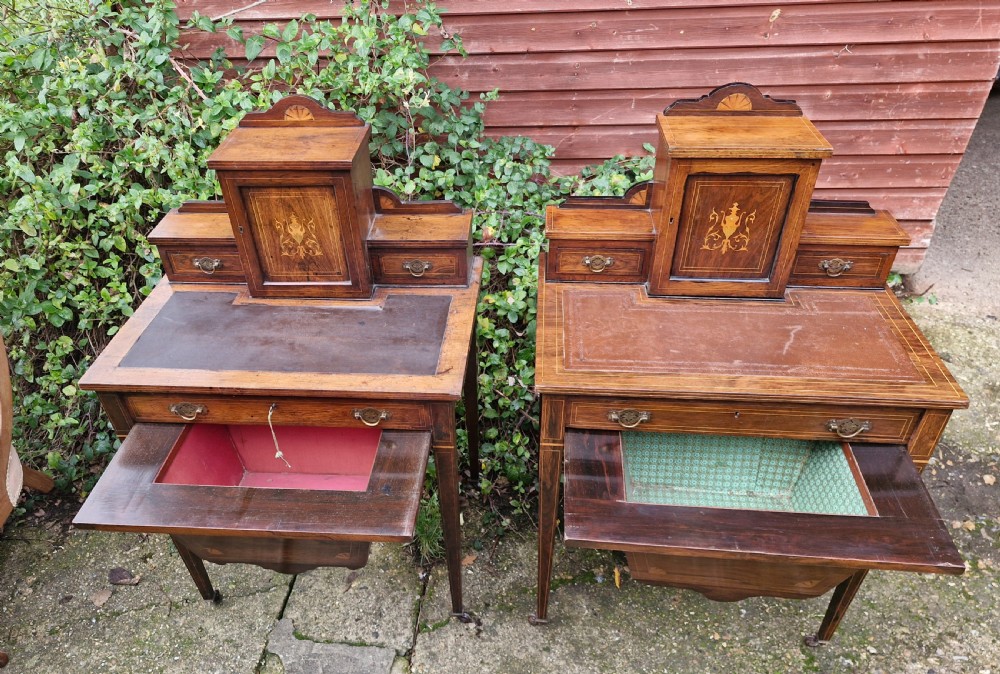 A pair of late Victorian rosewood writing tables featuring central raised cupboards with urn inlay, leather surfaces, and tapered square legs. View VI