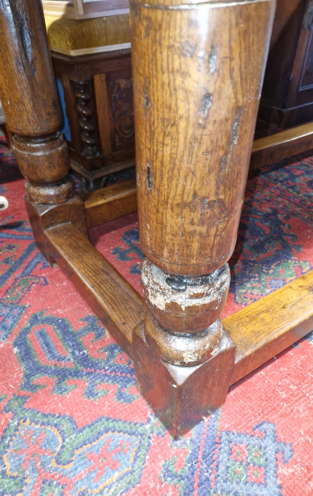 A rectangular dark oak refectory-style serving table featuring a carved frieze apron, turned legs, and a low box stretcher. View XVI