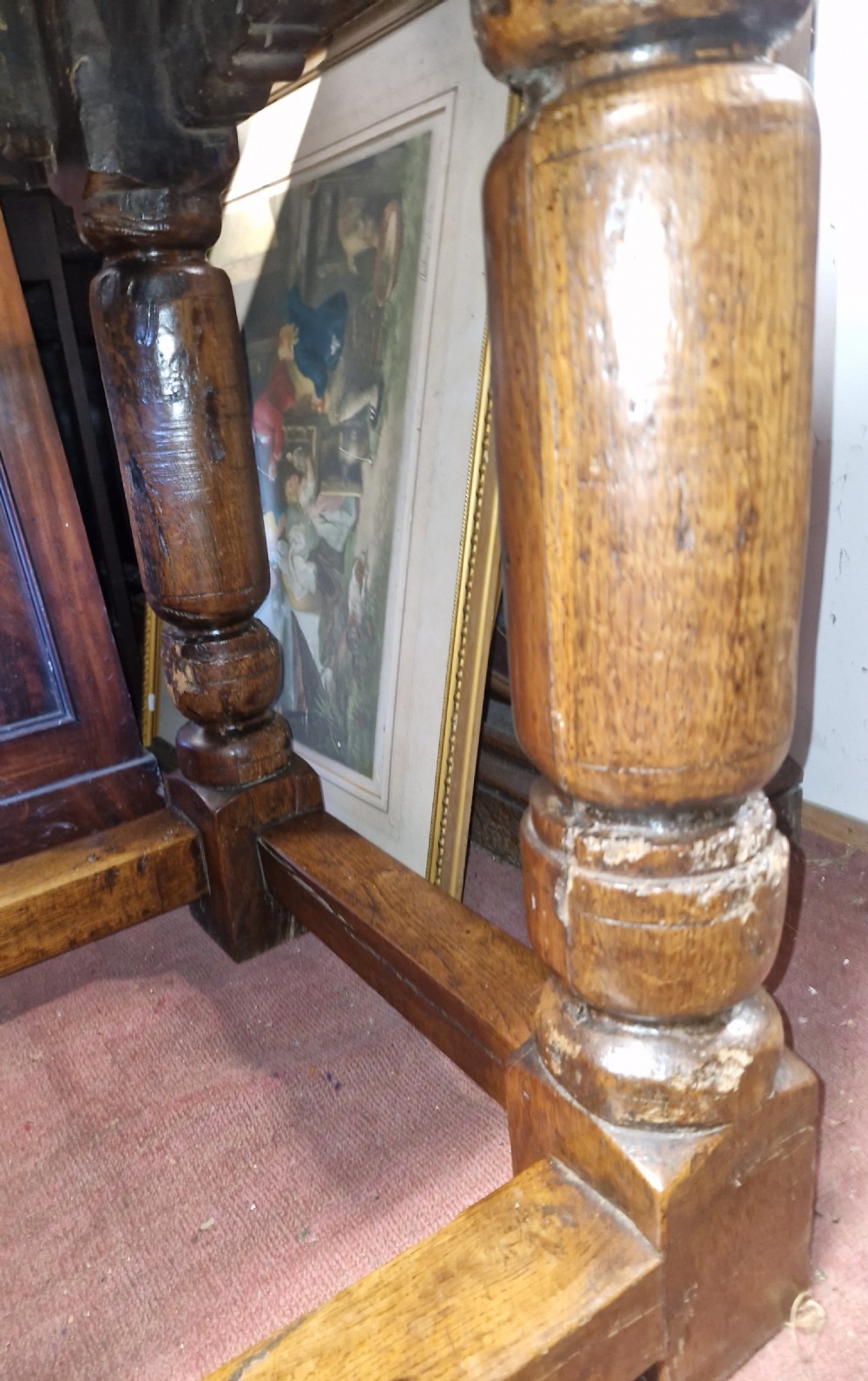A rectangular dark oak refectory-style serving table featuring a carved frieze apron, turned legs, and a low box stretcher. View XVII