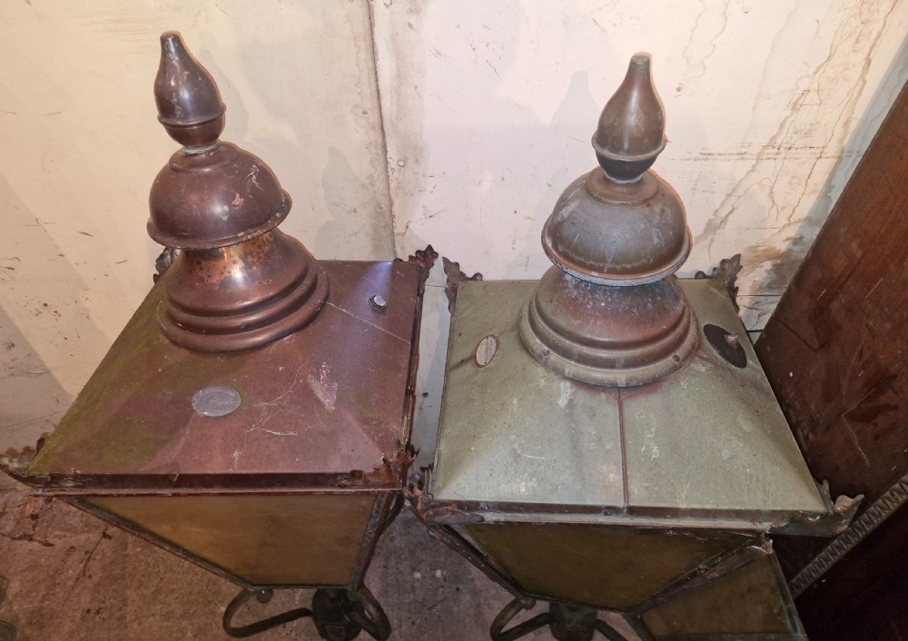 A pair of antique copper street lantern tops featuring tapered glazed panels, decorative finials, and scrolled iron mounts. View IV