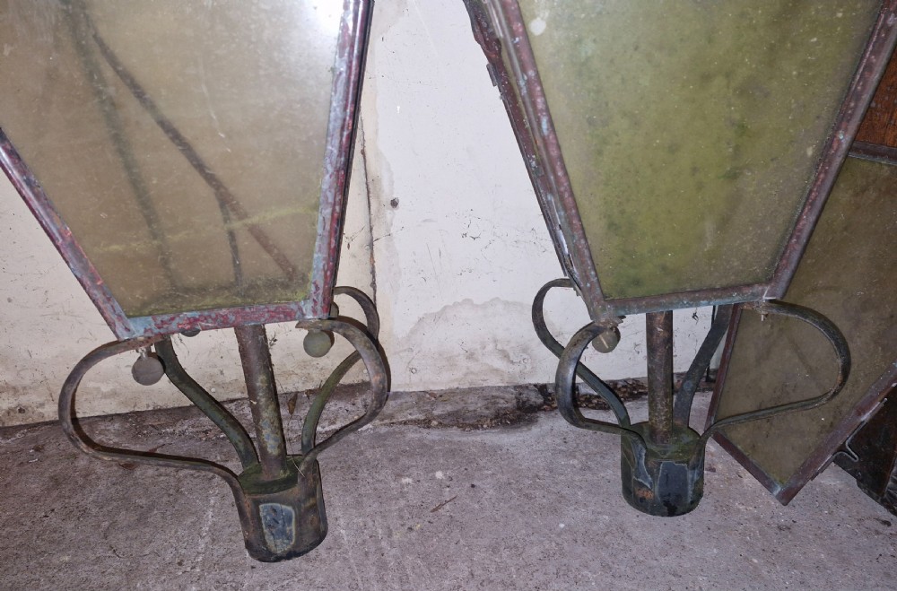 A pair of antique copper street lantern tops featuring tapered glazed panels, decorative finials, and scrolled iron mounts. View V