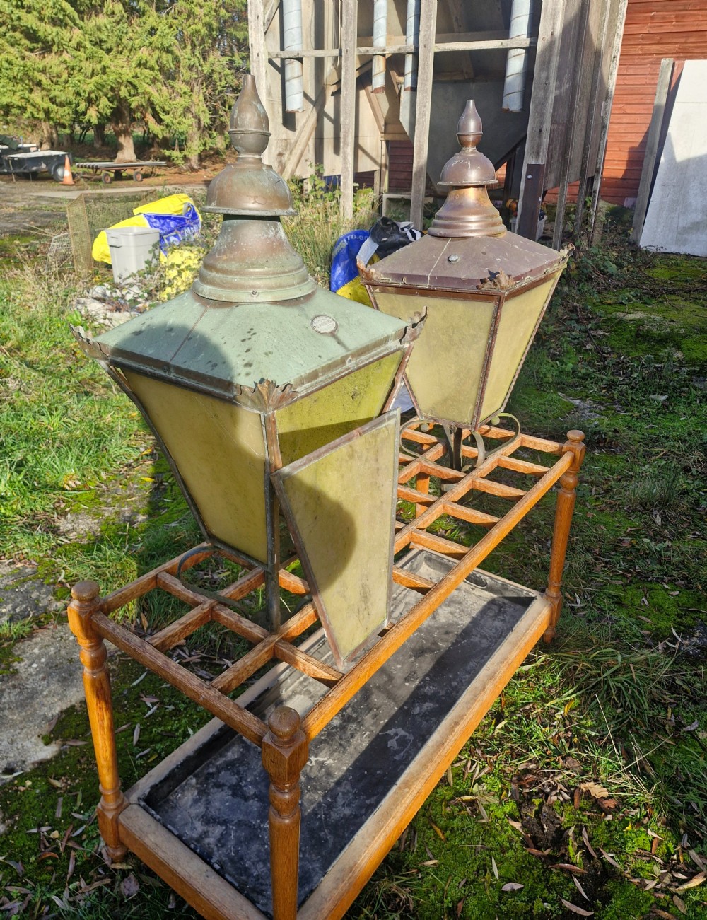 A pair of antique copper street lantern tops featuring tapered glazed panels, decorative finials, and scrolled iron mounts. View XIV
