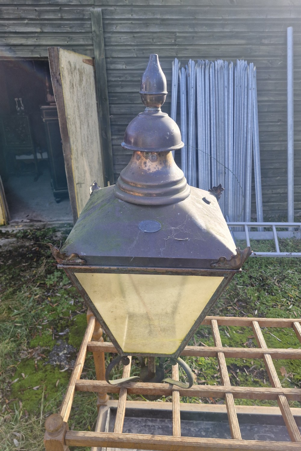 A pair of antique copper street lantern tops featuring tapered glazed panels, decorative finials, and scrolled iron mounts. View XVI