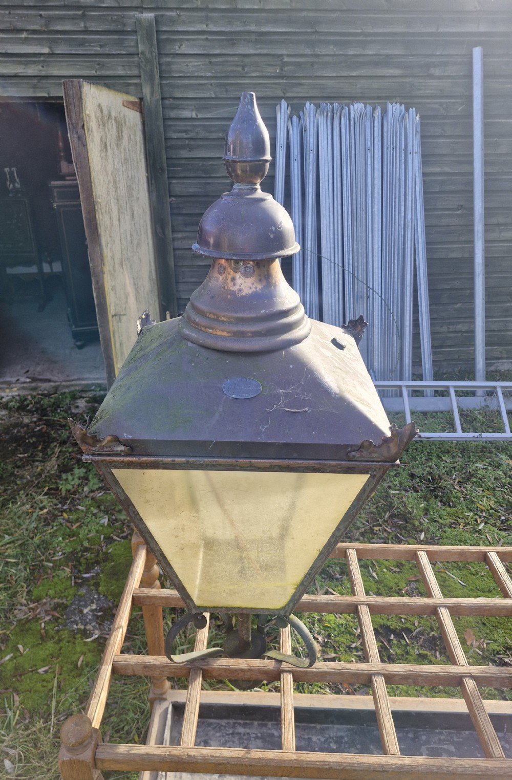 A pair of antique copper street lantern tops featuring tapered glazed panels, decorative finials, and scrolled iron mounts. View XX