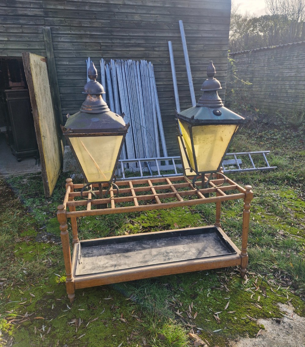 A pair of antique copper street lantern tops featuring tapered glazed panels, decorative finials, and scrolled iron mounts. View XXI