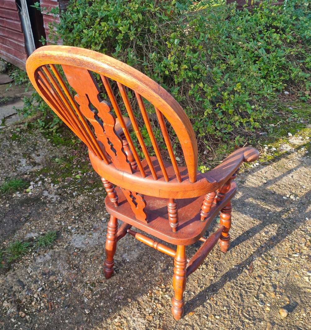A Victorian wooden Windsor armchair featuring a high hoop backrest, a pierced central splat, turned spindles, shaped armrests, and turned legs with stretchers. View VII