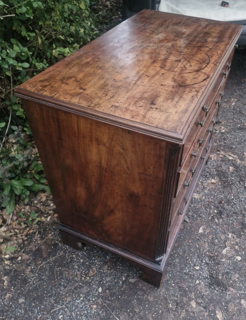 A Georgian mahogany bachelors chest featuring four drawers, a pull-out brushing slide, brass swan-neck handles, and bracket feet. View VI