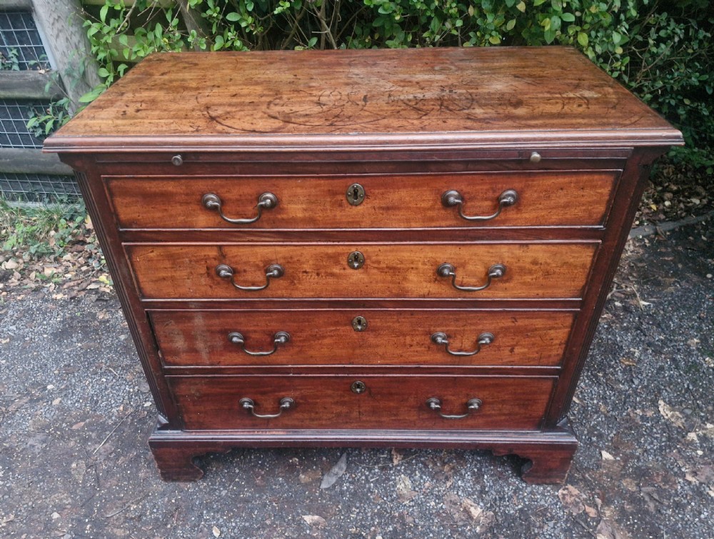 A Georgian mahogany bachelors chest featuring four drawers, a pull-out brushing slide, brass swan-neck handles, and bracket feet. View XII