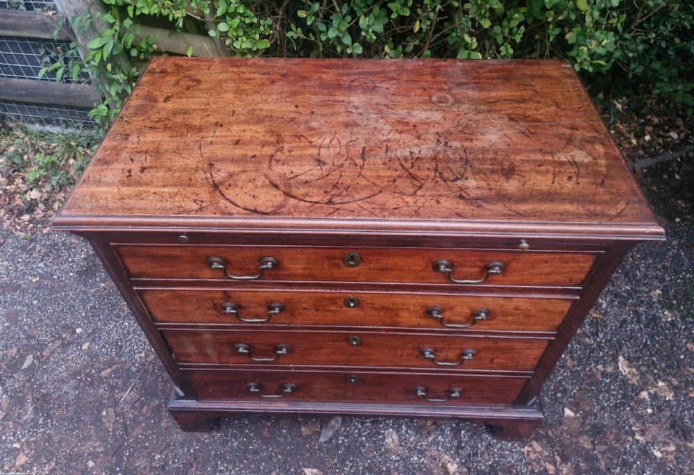 A Georgian mahogany bachelors chest featuring four drawers, a pull-out brushing slide, brass swan-neck handles, and bracket feet. View XIV