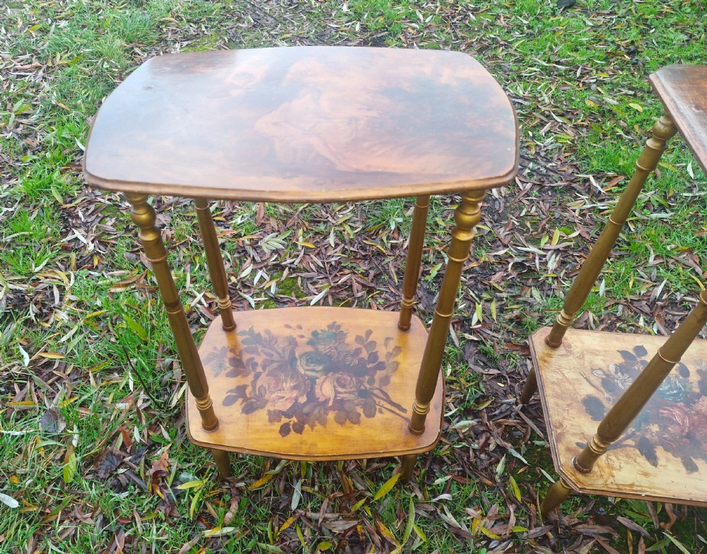 A pair of two-tier rectangular occasional tables featuring gold-painted turned legs, painted figurative scenes on the top surfaces, and floral artwork on the lower shelves. View II