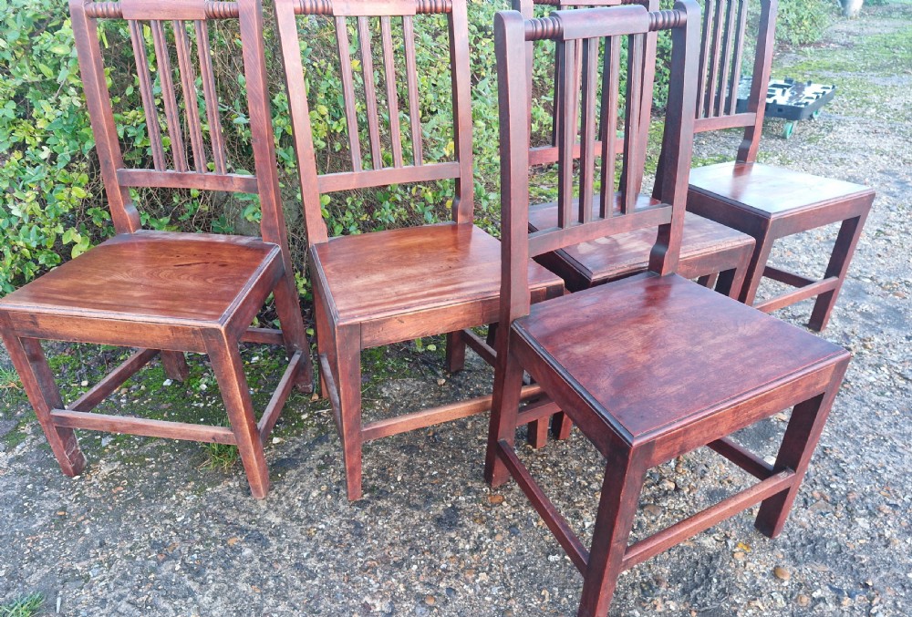 A set of five early Victorian dark-stained timber dining chairs featuring vertical slat backs, turned top rails, solid wooden seats, and straight legs with stretchers. View III