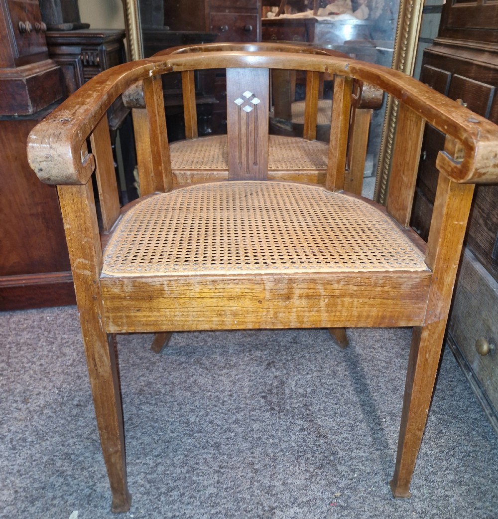 A pair of Anglo Indian Art Deco teak armchairs featuring curved horseshoe backrests with diamond inlay and woven cane seats. View IV
