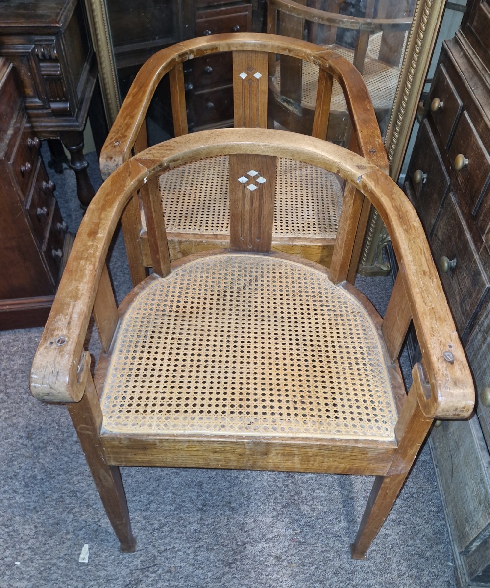 A pair of Anglo Indian Art Deco teak armchairs featuring curved horseshoe backrests with diamond inlay and woven cane seats. View VII