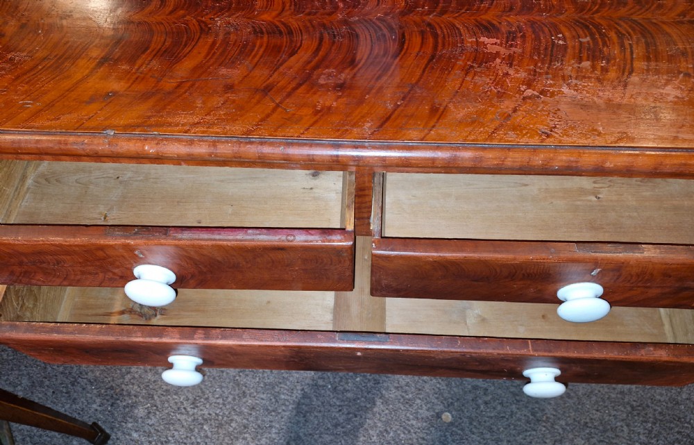 A Victorian pine chest of drawers featuring a warm brown scumbled faux-grain painted finish, two short drawers over three long drawers, and white turned handles. View II