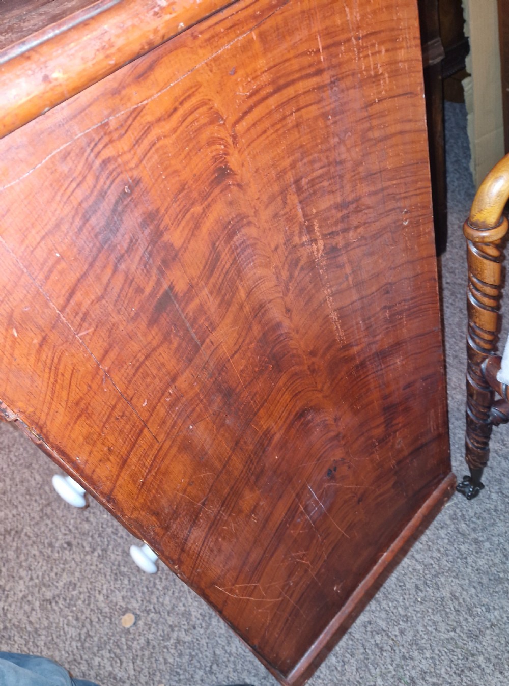 A Victorian pine chest of drawers featuring a warm brown scumbled faux-grain painted finish, two short drawers over three long drawers, and white turned handles. View V