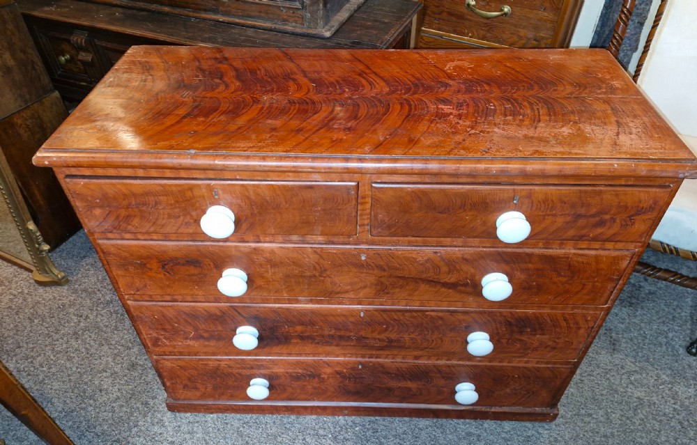 A Victorian pine chest of drawers featuring a warm brown scumbled faux-grain painted finish, two short drawers over three long drawers, and white turned handles. View VII