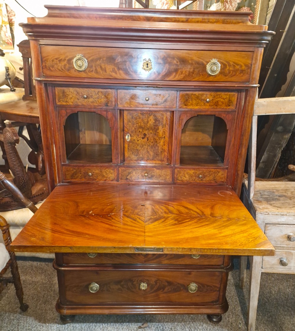 A 19th-century mahogany fall-front escritoire featuring flame mahogany veneer panels, a drop-down writing surface, multiple storage drawers, and brass fittings. View III
