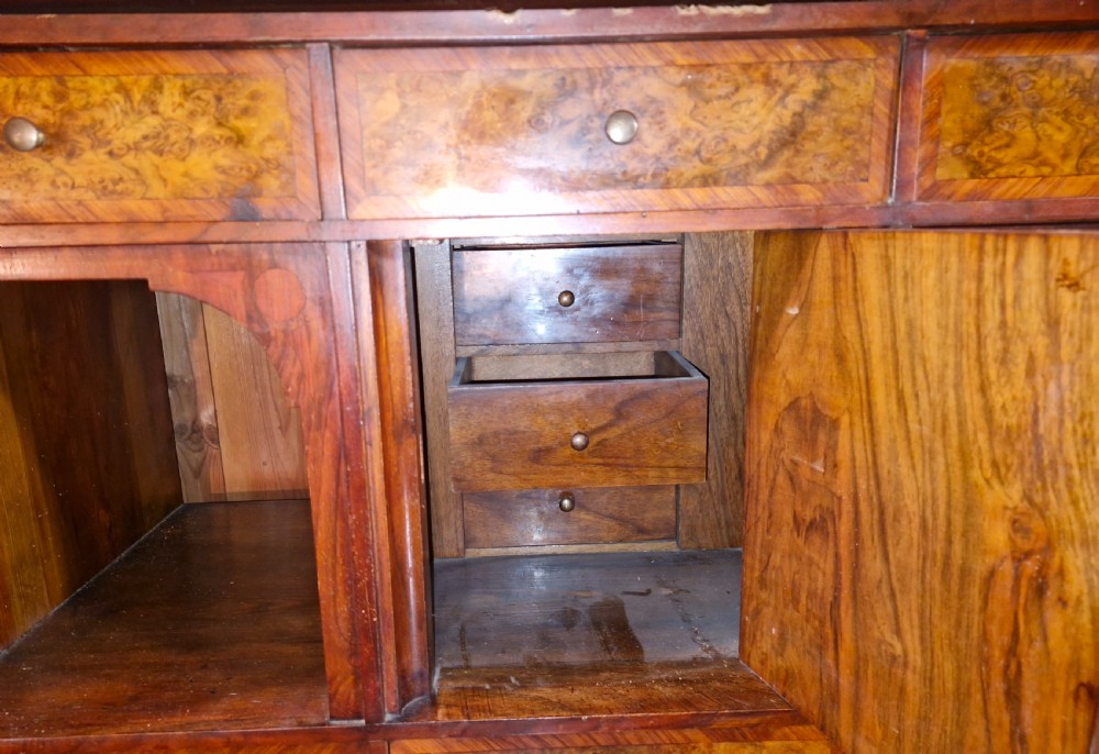 A 19th-century mahogany fall-front escritoire featuring flame mahogany veneer panels, a drop-down writing surface, multiple storage drawers, and brass fittings. View VI