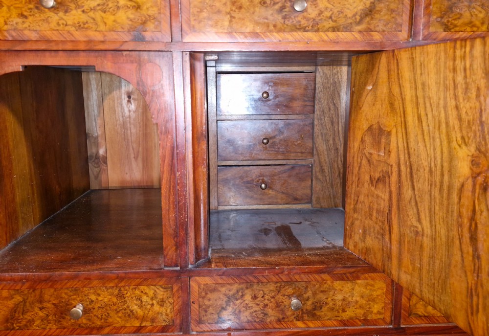 A 19th-century mahogany fall-front escritoire featuring flame mahogany veneer panels, a drop-down writing surface, multiple storage drawers, and brass fittings. View VII