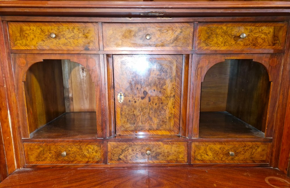 A 19th-century mahogany fall-front escritoire featuring flame mahogany veneer panels, a drop-down writing surface, multiple storage drawers, and brass fittings. View VIII